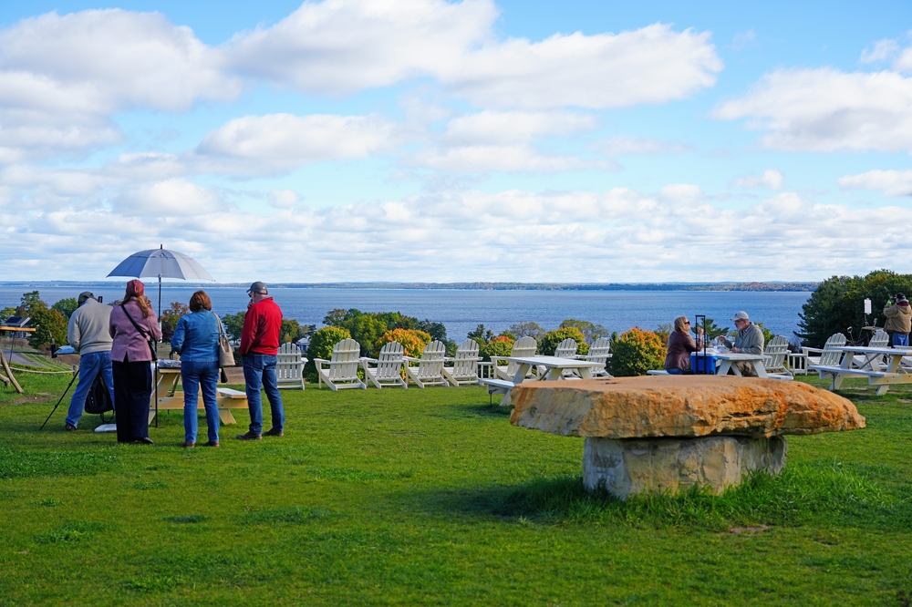 people stood and sat in a tasting area overlooking the bay. The article is about Northern Michigan Wine Country.  