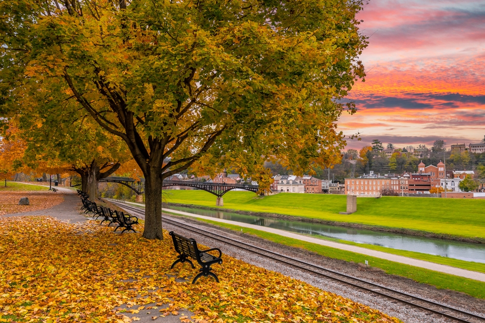 view of a park in a town with fall colors as the sky turns orange midwest fall scenic drives