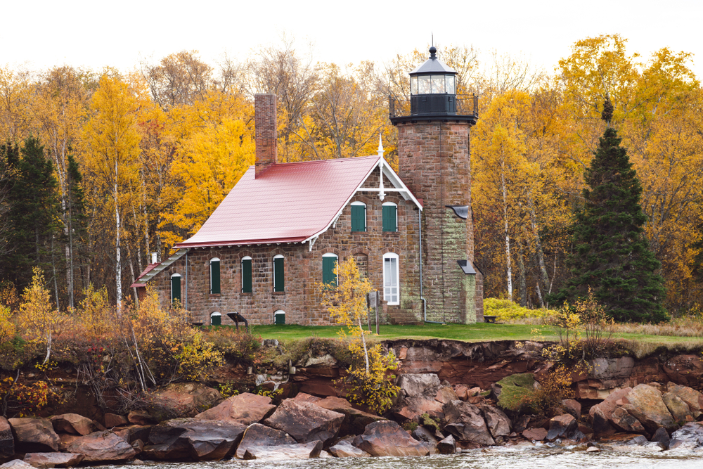 lighthouse surrounded by fall trees