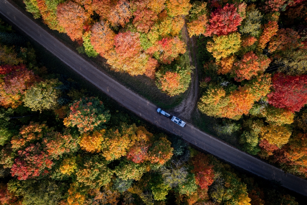 aerial view of a road between fall forest midwest fall scenic drives
