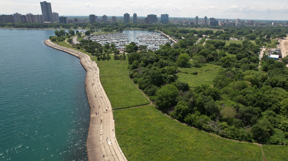 Montrose Beach bird sanctuary in Chicago taken from above. you can see a large green area with a lake in the background. you can also see the city. it is one of the hidden gems in Chicago. 